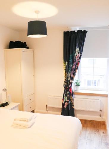 a bedroom with a black curtain and a window at The Queen's Head Hotel in Buxton