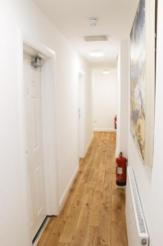 a hallway with white walls and a wooden floor at The Queen's Head Hotel in Buxton