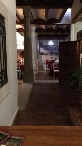 
a room with a table, chairs, and a window at Hotel Casas del sevillano in El Tornadizo
