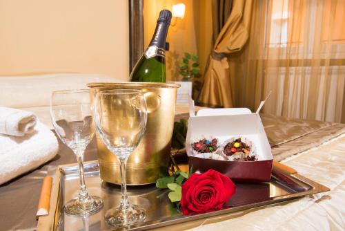 a tray with a cake and wine glasses on a bed at Domus RomAntica in Rome