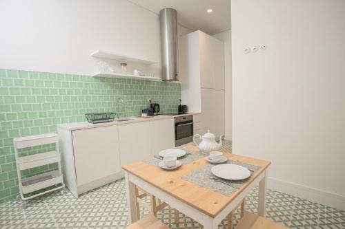 a kitchen with a wooden table in a room at Montebelo Lx Dwt Apartments in Lisbon