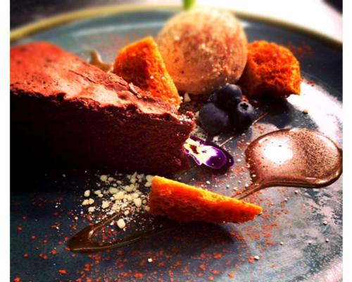 a plate with a piece of cake and blueberries at Seabreeze Restaurant With Rooms in Aberdyfi