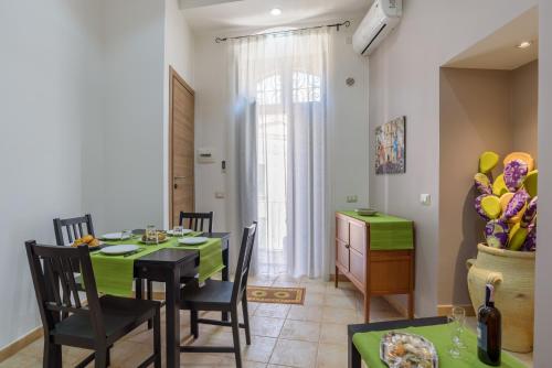 une salle à manger avec une table et des chaises vertes dans l'établissement Le Quattro Colline, à Modica