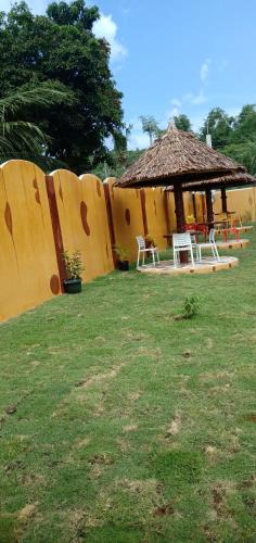 a gazebo with a table and chairs next to a fence at E&N Paradise Island Resort in Siquijor