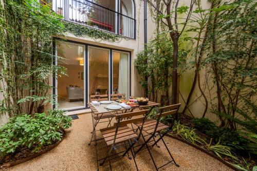 a patio with a table and chairs and plants at My Suite Lisbon Serviced Apartments - Principe Real in Lisbon