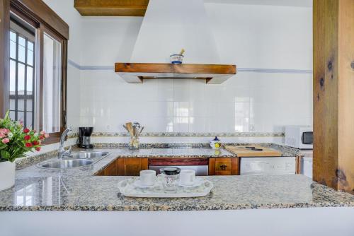 a white kitchen with a sink and a counter top at Casa Villanueva 4 - Sólo Familias in Hozanejos