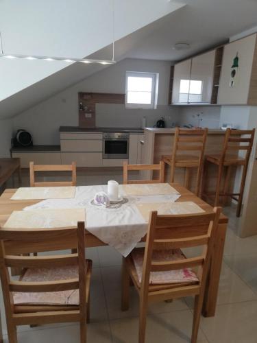 ein Esszimmer mit einem Tisch und Stühlen sowie eine Küche in der Unterkunft Slavuj in Novi Sad