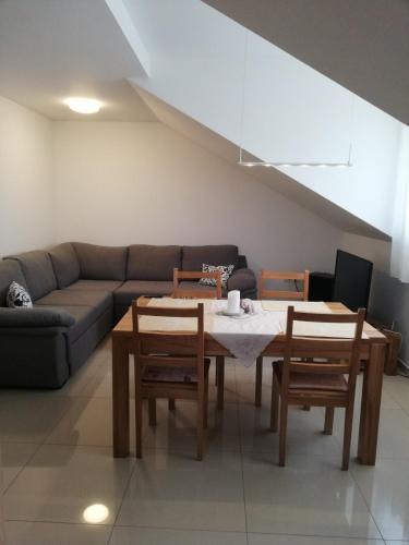 ein Wohnzimmer mit einem Sofa, einem Tisch und Stühlen in der Unterkunft Slavuj in Novi Sad