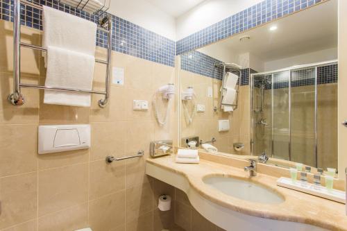 La salle de bains est pourvue d'un lavabo et d'un miroir. dans l'établissement Hestia Hotel Ilmarine, à Tallinn