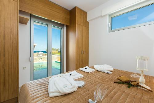 a bedroom with a bed with towels on it at Thalasses in Adelianos Kampos
