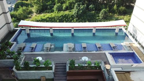 an overhead view of a large swimming pool with chairs and a pavilion at CM Park Hotel in Andong