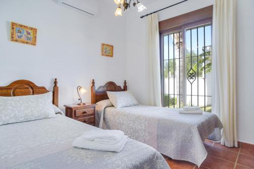 a bedroom with two beds and a window at Casa Villanueva 4 - Sólo Familias in Hozanejos