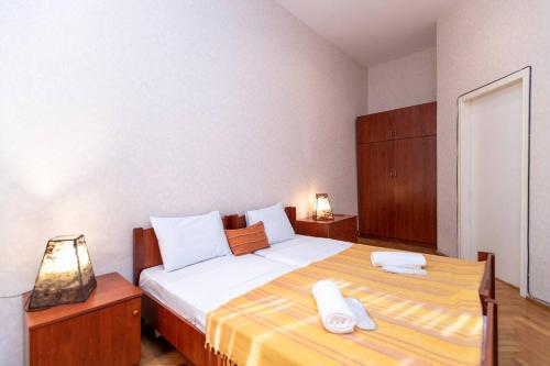 a bedroom with a large bed with towels on it at Wehost Cozy and colorful apartment with balcony in Tbilisi City