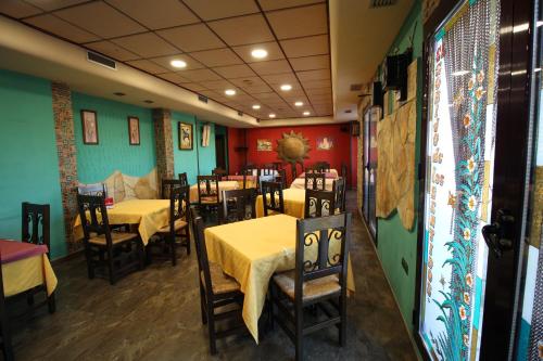 un restaurante con mesas y sillas con mantel amarillo en El Rincon de Piedra en Enguídanos