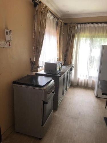 a kitchen with a stove and a microwave at Tatys homestay in Dar es Salaam