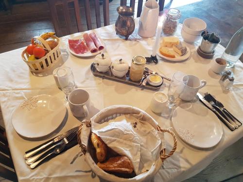 Les Pierres Davélie في Saint-Éloy-la-Glacière: طاولة عليها قماش الطاولة البيضاء مع الطعام