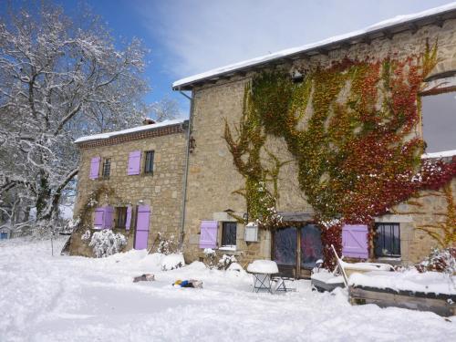 Les Pierres Davélie في Saint-Éloy-la-Glacière: مبنى بأبواب أرجوانية في الثلج