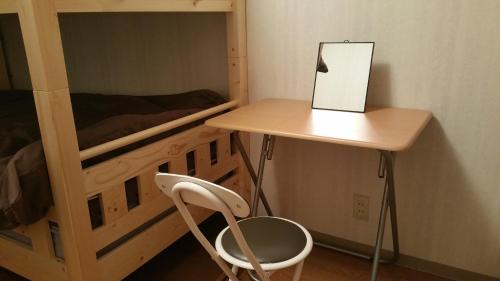 escritorio y silla junto a una litera en Home Sharing Guest House Don en Takayama