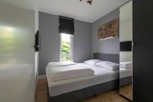 een slaapkamer met een bed en een raam bij Eureka 99 - Sint Maartenszee in Sint Maartenszee