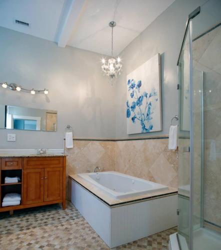 a bathroom with a tub and a sink and a mirror at Huge 5 bed, 5 bath in Historic Downtown Savannah in Savannah
