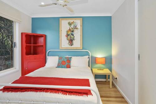 a bedroom with a bed with a red door at SEAVIEW - ocean views from a modern townhouse in Apollo Bay
