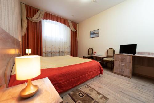 a hotel room with a bed and a television at Prince Vladimir in Vladimir
