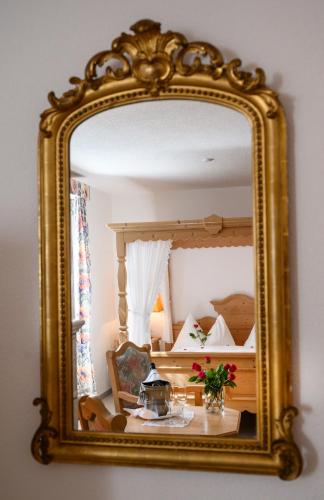 a mirror reflecting a bedroom with a bed in it at Landgasthof zu den drei Sternen in Brunegg