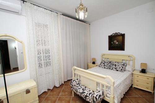 Schlafzimmer mit einem Bett, einem TV und einem Spiegel in der Unterkunft Casa Rural Mérida in Aljucén