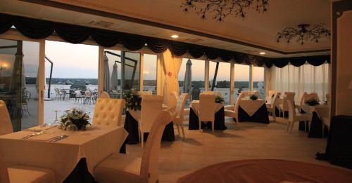 - un restaurant avec des tables et des chaises blanches offrant une vue dans l'établissement Hotel Madonna Delle Grazie, à Ceglie Messapica