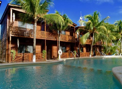 un complejo con piscina frente a un edificio en Cabañas Coconut by MIJ, en Isla Holbox