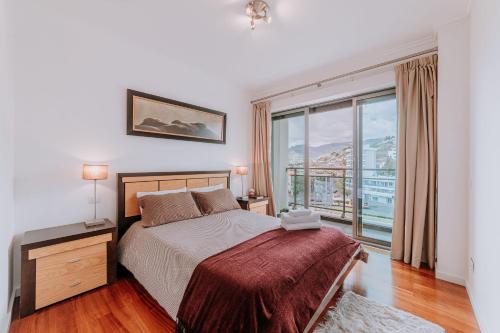 a bedroom with a bed and a large window at Cozy T2 with Ocean View in Funchal