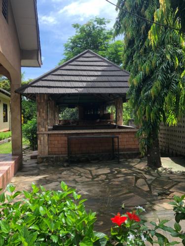a gazebo with a bench in a yard at Tatys homestay in Dar es Salaam