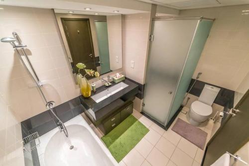 a bathroom with a shower and a tub and a toilet at Divine Burj & Opera Views - 2BDR - DOWNTOWN DUBAI in Dubai
