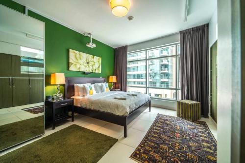 a bedroom with a bed and a green wall at Divine Burj & Opera Views - 2BDR - DOWNTOWN DUBAI in Dubai