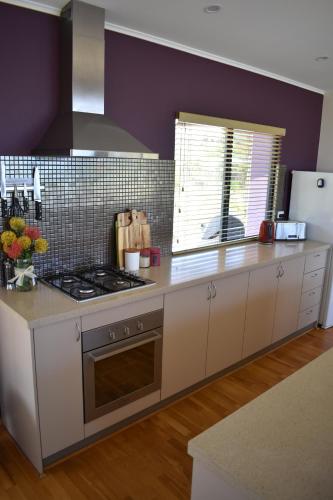a kitchen with white cabinets and a stove top oven at Redgate Beach Escape in Witchcliffe