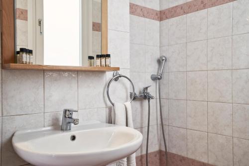 a bathroom with a sink and a shower at Favie Suzanne in Tinos Town