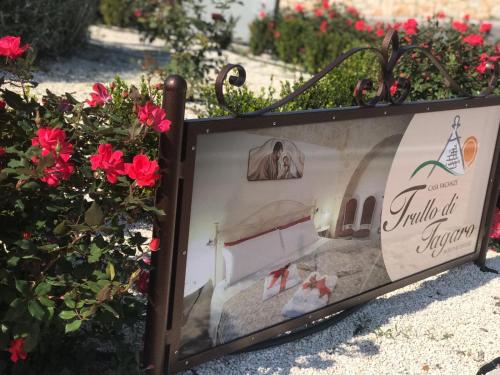 a framed picture of a bed with red flowers at Trullo Di Tagaro in Locorotondo