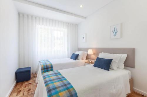 a bedroom with two beds and a window at Old Market Apartment in Guimarães