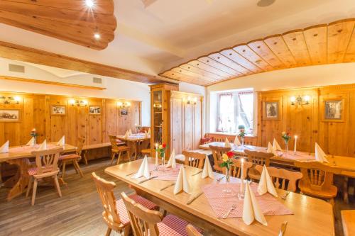 a restaurant with wooden walls and tables and chairs at Landhotel & Gasthof Baiernrain in Baiernrain