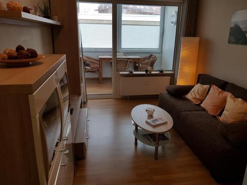 a living room with a couch and a table at Haus Seelord am Weststrand in Norderney