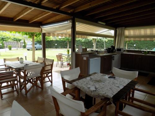 a kitchen and dining room with tables and chairs at Alisachni in Paralia Panteleimonos