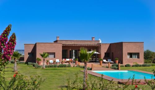 a villa with a swimming pool and a resort at DOMAINE VILLA PRIVE in Marrakesh