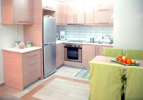 a kitchen with a refrigerator and a plate of fruit on a table at Athens Quality Apartments in Athens