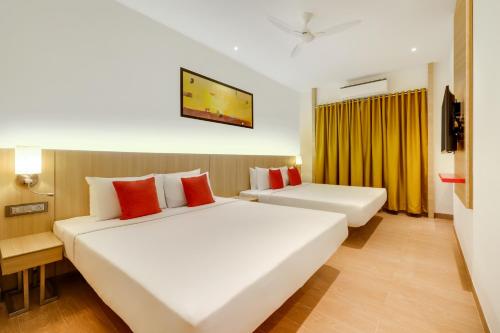 a hotel room with two beds and a tv at Red Fox Hotel, Vijayawada in Vijayawāda