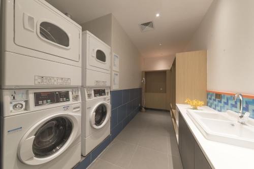 a laundry room with two washing machines and a sink at Holiday Inn Express Xiamen Airport Zone by IHG in Xiamen
