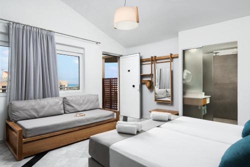 a bedroom with two beds and a couch at Maleme Mare in Maleme