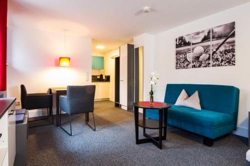 ein Wohnzimmer mit einem blauen Sofa und einem Tisch in der Unterkunft Appartements am Rindhof in Münnerstadt