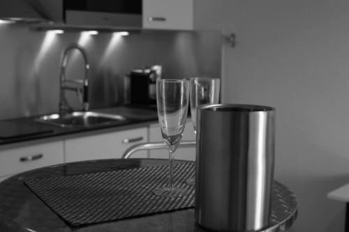 due bicchieri da vino seduti su un bancone in cucina di Appartement avec Balcon Immeuble Standing a Lione