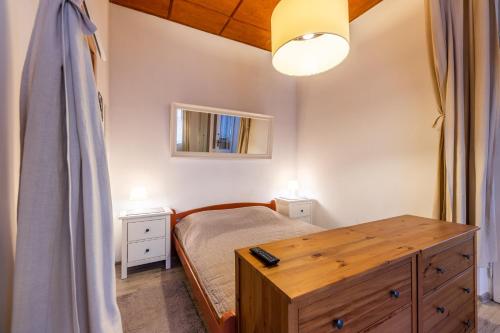 a bedroom with a bed and a dresser and a mirror at Victus Apartamenty, Victus Apartament Fiord in Sopot