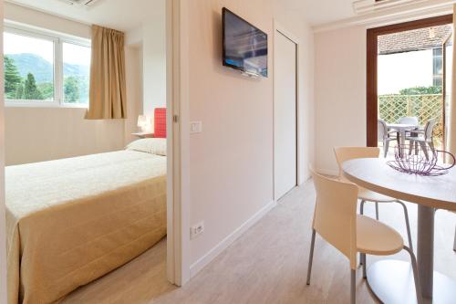 een slaapkamer met een bed en een tafel en stoelen bij Residence Lenno in Lenno